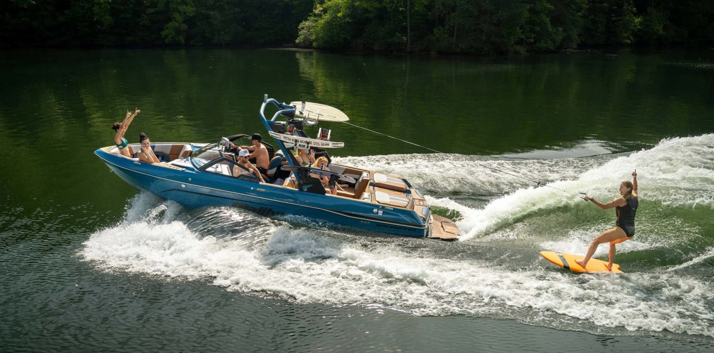 Malibu LSV 23 boat on the water with a rider behind it on a wakeboard