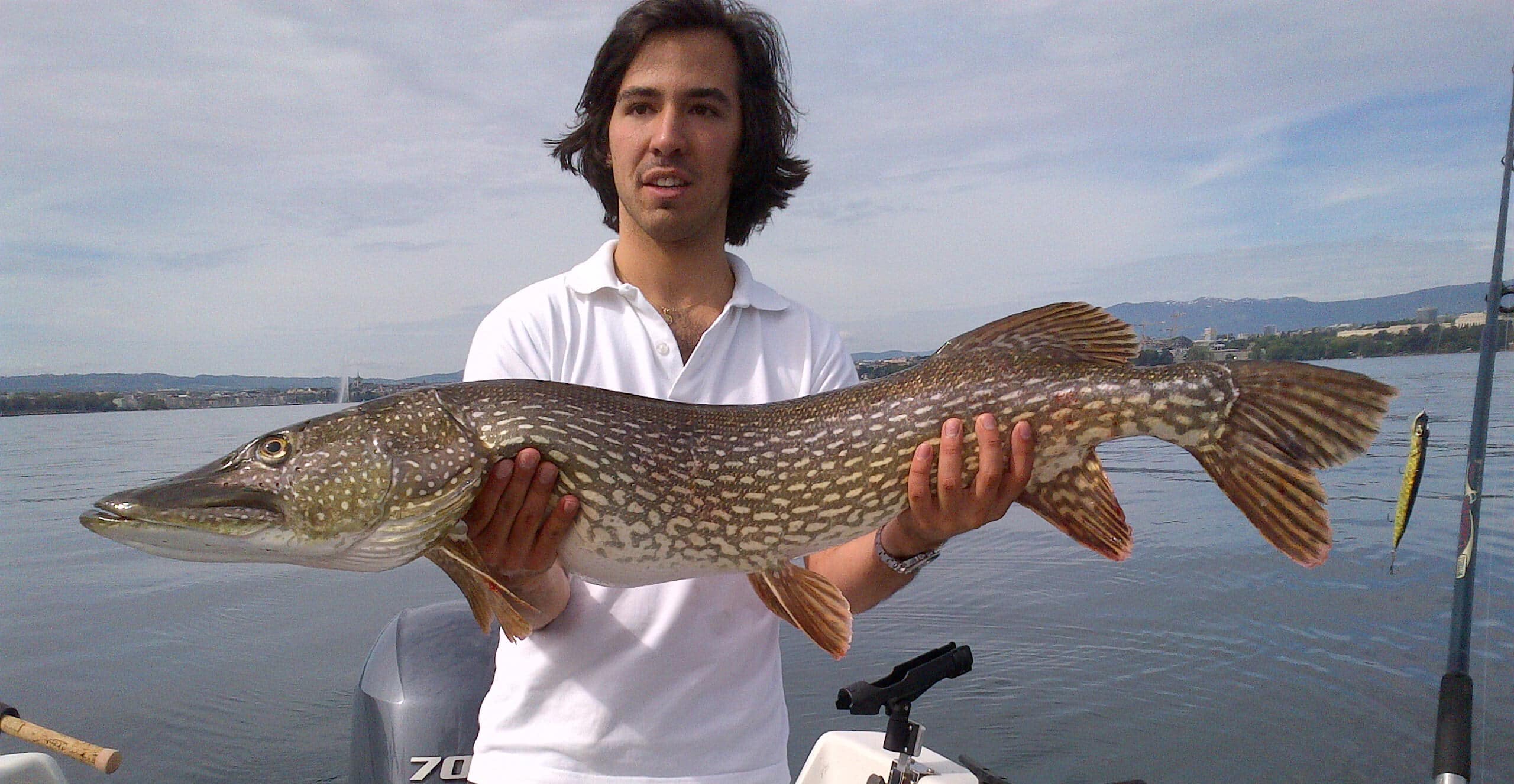 A man showing a big pike ("brochet") fished in Lake Geneva